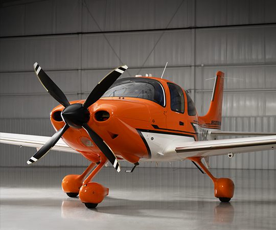 Orange aircraft parked in hangar