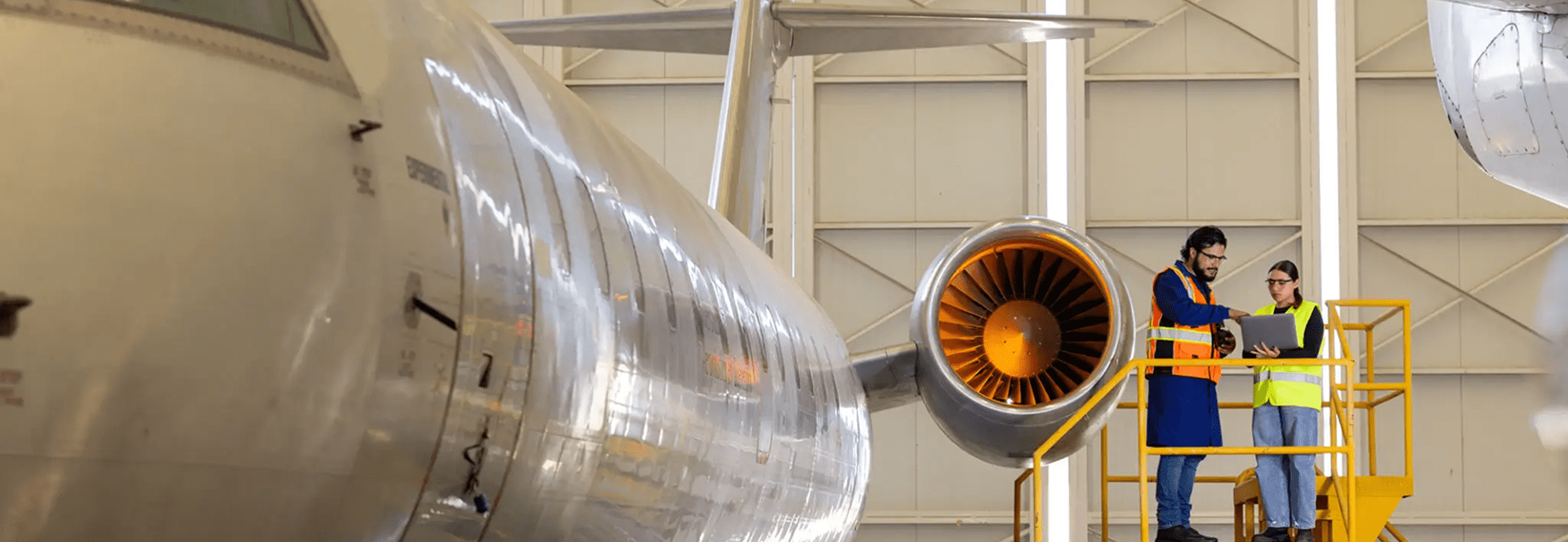 Aircraft maintenance workers inspecting jet engine